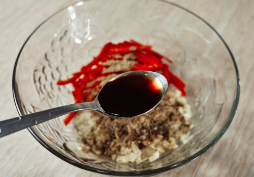Pouring soy sauce into the marinade bowl