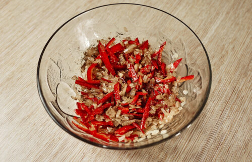 Bowl with onion, bell pepper, soy sauce, vinegar, sugar, and coriander