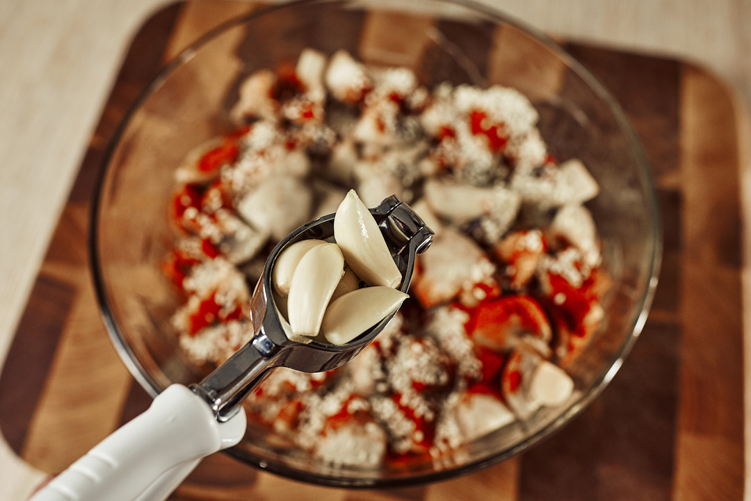 Pressing fresh garlic into the mushroom mixture