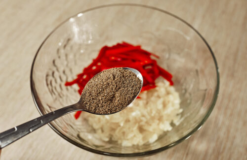 Adding red bell pepper and ground coriander to onion
