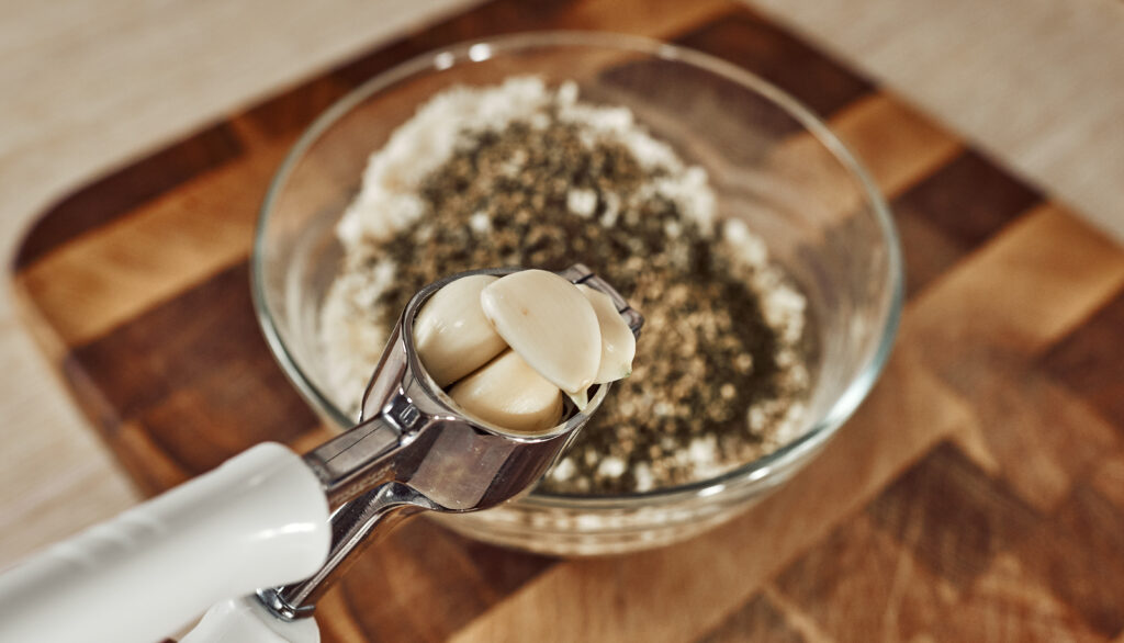 Adding minced garlic to the cauliflower coating mixture