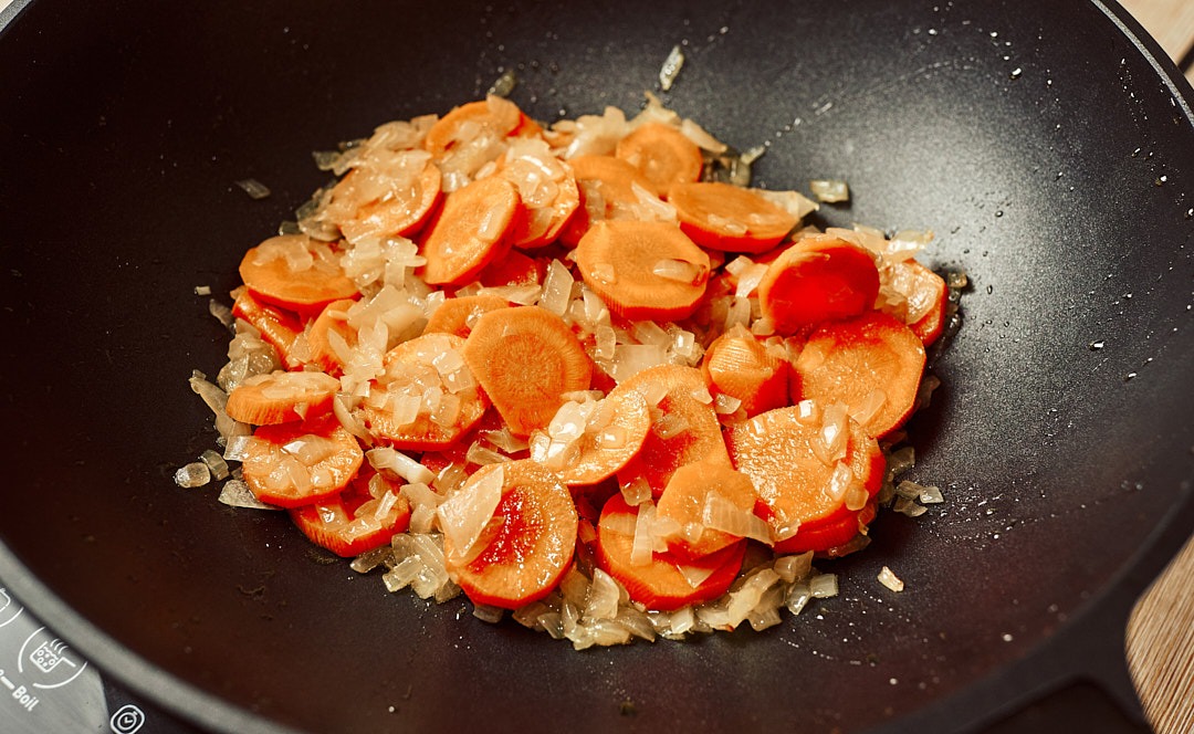 Adding sliced carrots to the pan