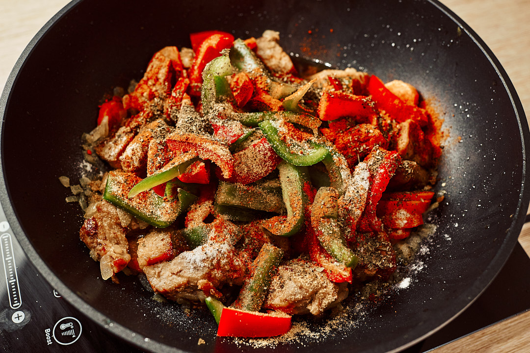 Seasoning pork and vegetables with paprika and spices