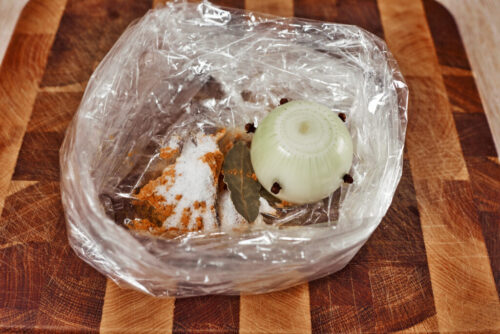placing onion and spices into baking bag