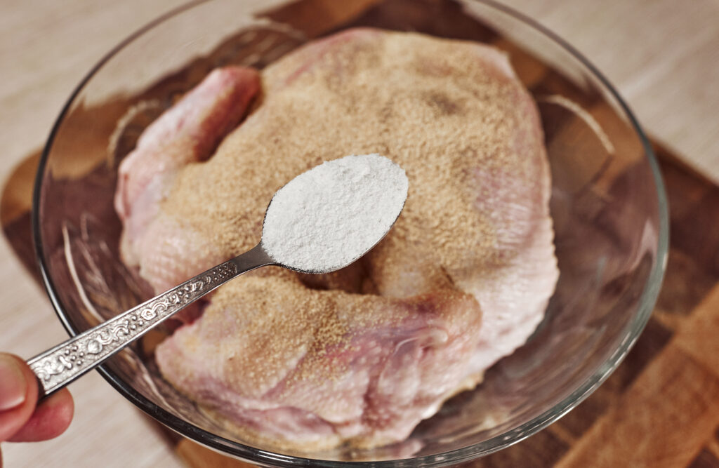 sprinkling salt over whole chicken