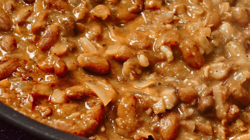 Creamy white beans in a pot topped with parsley