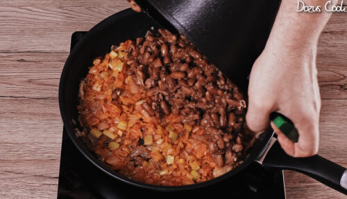 Stirring aromatics into beans for a creamy sauce