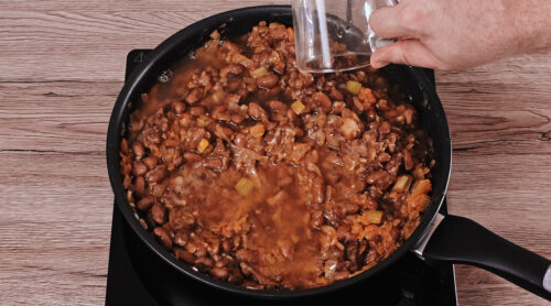 Adding water if the beans become too dry.