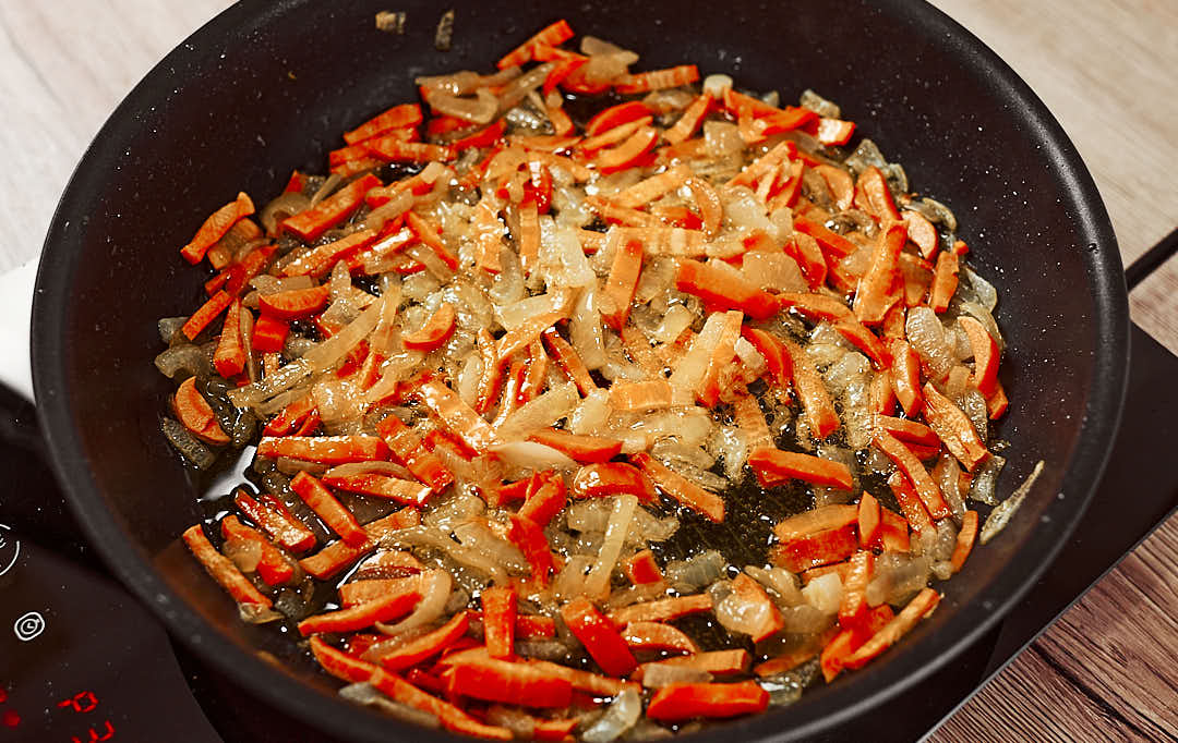 Sauteed onion and carrot in a pan