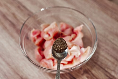 Add black pepper to chopped chicken bites