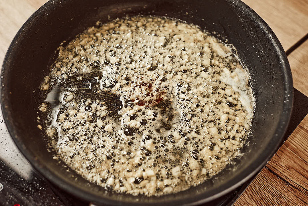 Cooking garlic butter sauce in skillet