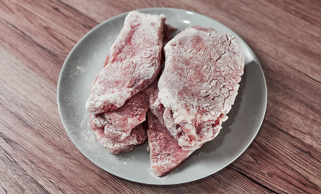 Dredging pork cutlets in flour