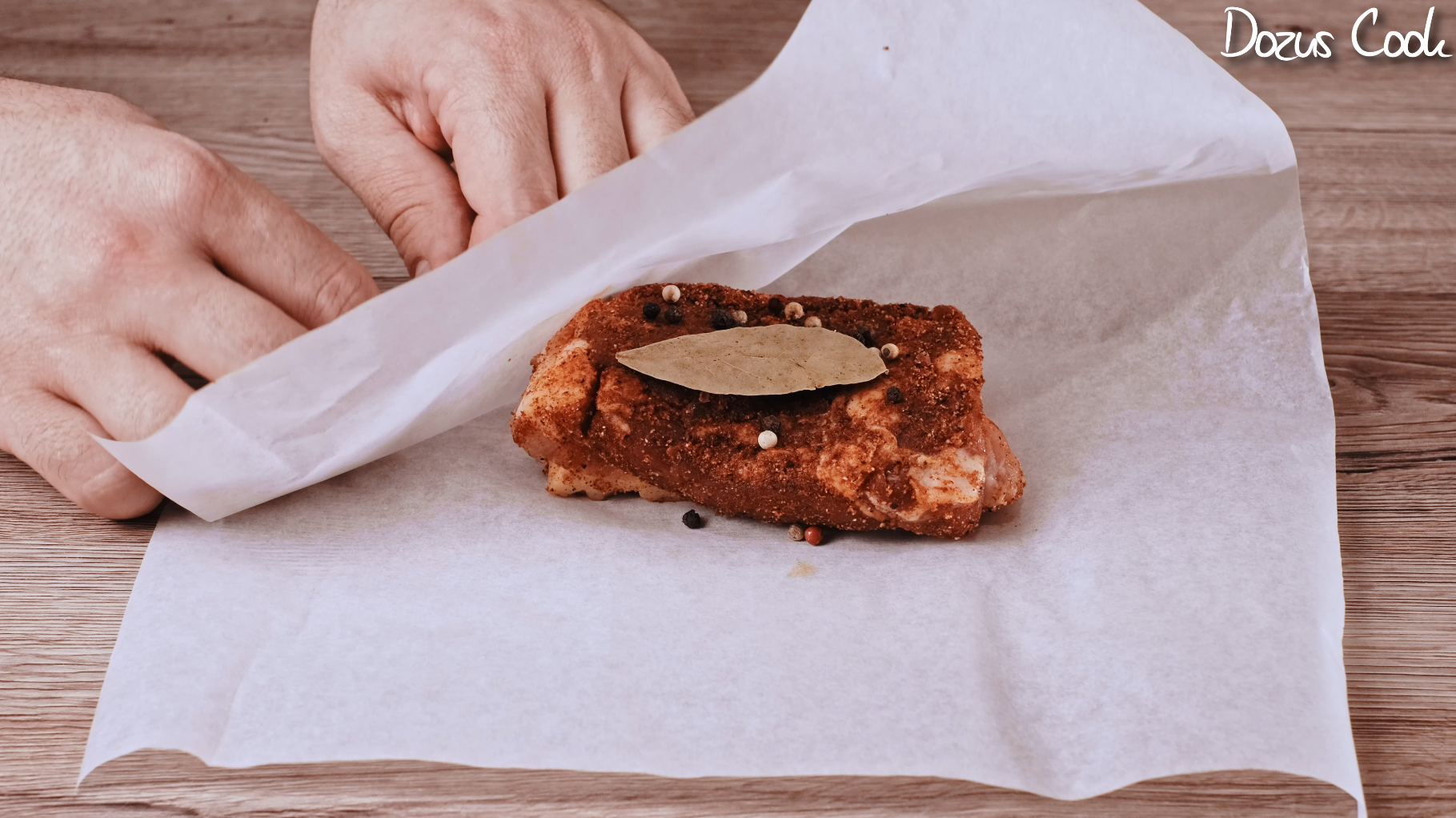 Wrapping pork belly in parchment with peppercorns and leaf