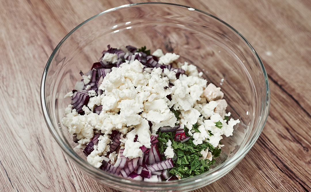 Chicken, red onion and parsley mixed in a bowl for keto salad