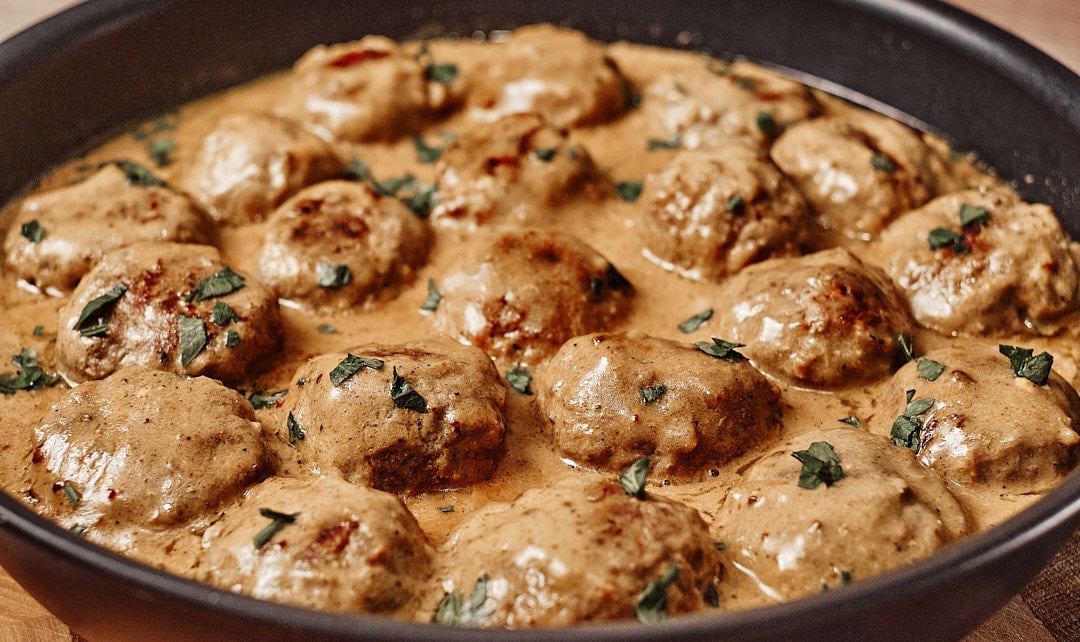 Simmering meatballs in creamy gravy