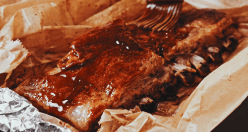 Unwrapping ribs before glazing with BBQ sauce