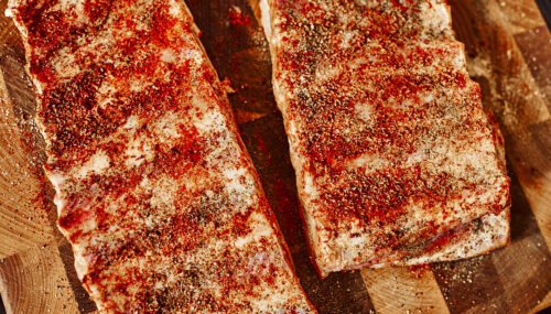 Dry rub sprinkled evenly over pork ribs