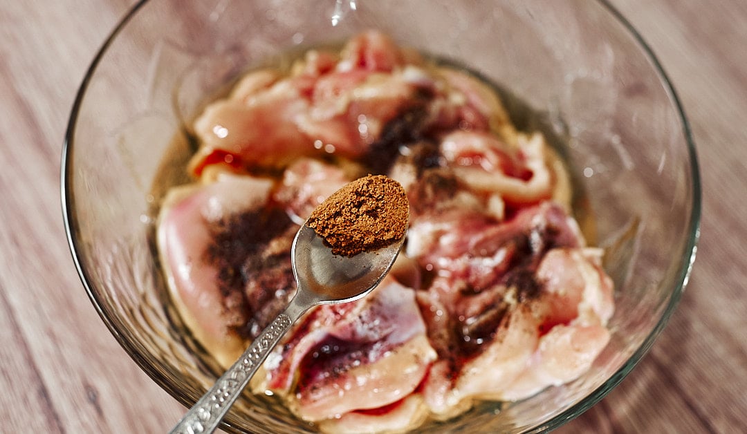 Seasoning chicken thighs with paprika, coriander and chili
