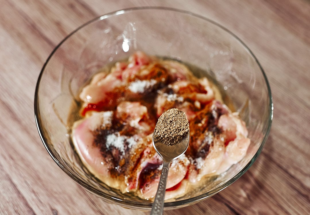 Seasoning chicken thighs with paprika, black pepper coriander and chili