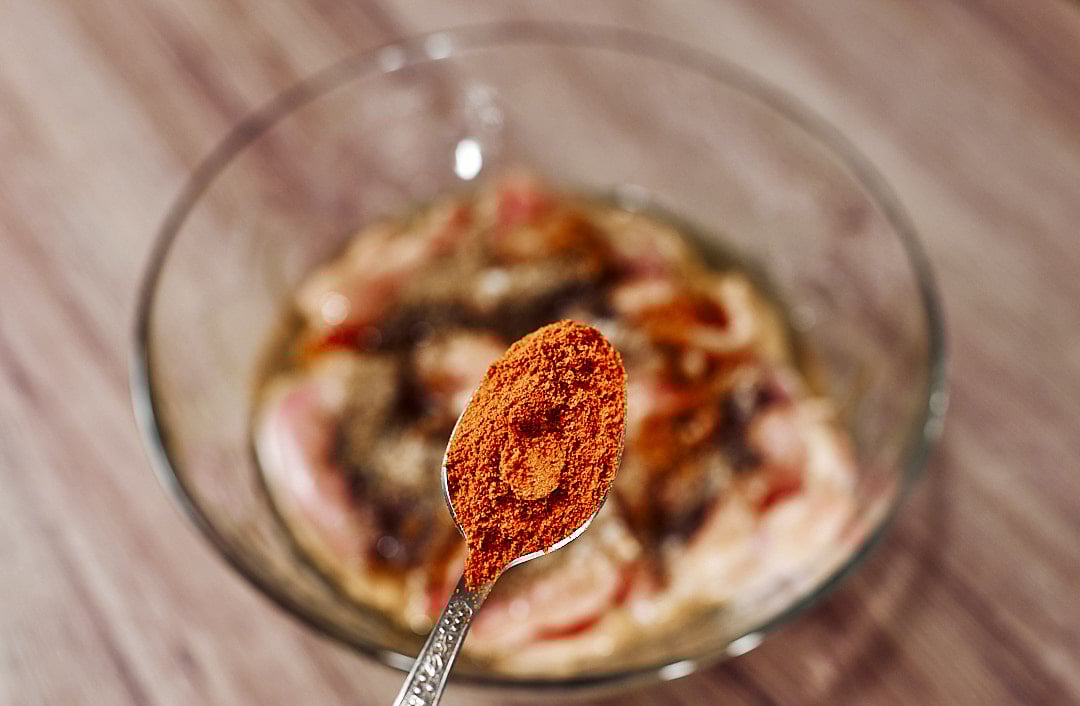 Seasoning chicken thighs with paprika, black pepper coriander and chili
