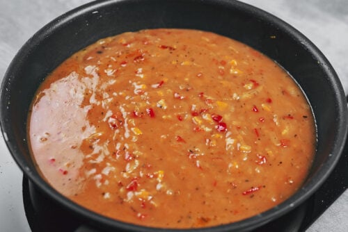 Stirring the flour into the vegetables to form the sauce base