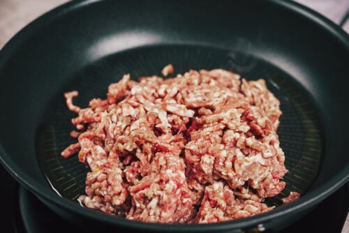 Ground meat beginning to cook in a skillet