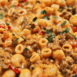 Creamy cheesy tomato pasta served in a bowl with fresh parsley on top