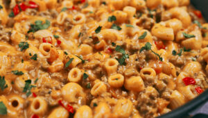 Creamy cheesy tomato pasta served in a bowl with fresh parsley on top