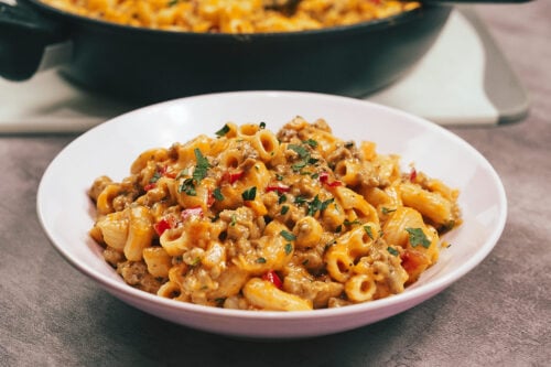 Creamy cheesy tomato pasta served in a bowl with fresh parsley on top