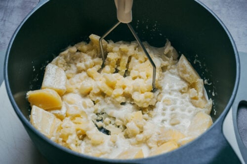 Potatoes partially mashed with masher