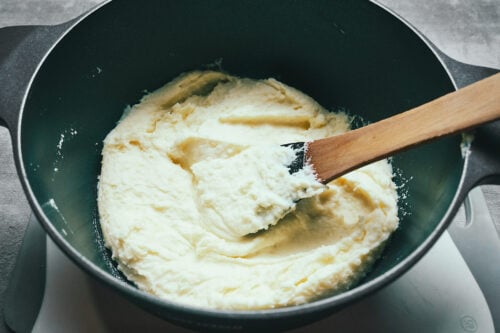 Cream cheese being mixed into mashed potatoes