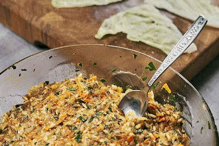 Cabbage roll filling placed on a cut cabbage leaf piece.