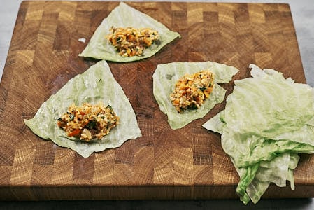 Cabbage leaves filled with meat and rice mixture before rolling.