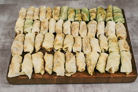 Cabbage leaf filled with meat and rice mixture ready to be rolled into a stuffed cabbage roll.
