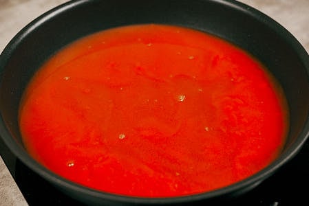 Tomato sauce simmering in a saucepan.