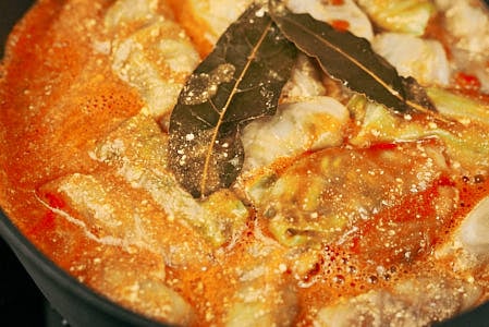 Simmered tomato sauce with sour cream and bay leaves for stuffed cabbage rolls.