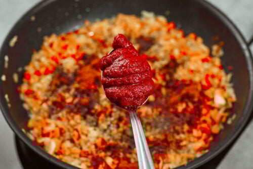 Tomato paste added to vegetable base for creamy chicken meatballs sauce