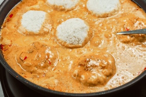 Chicken meatballs simmering in creamy sauce