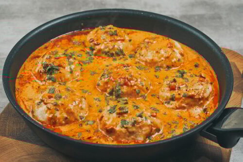 Creamy chicken meatballs finished in skillet with sauce