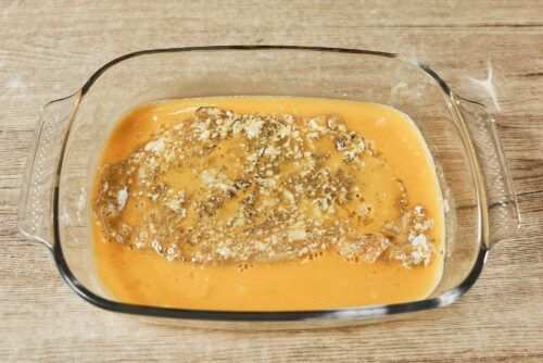 Pork cutlet dipped into beaten eggs before breading