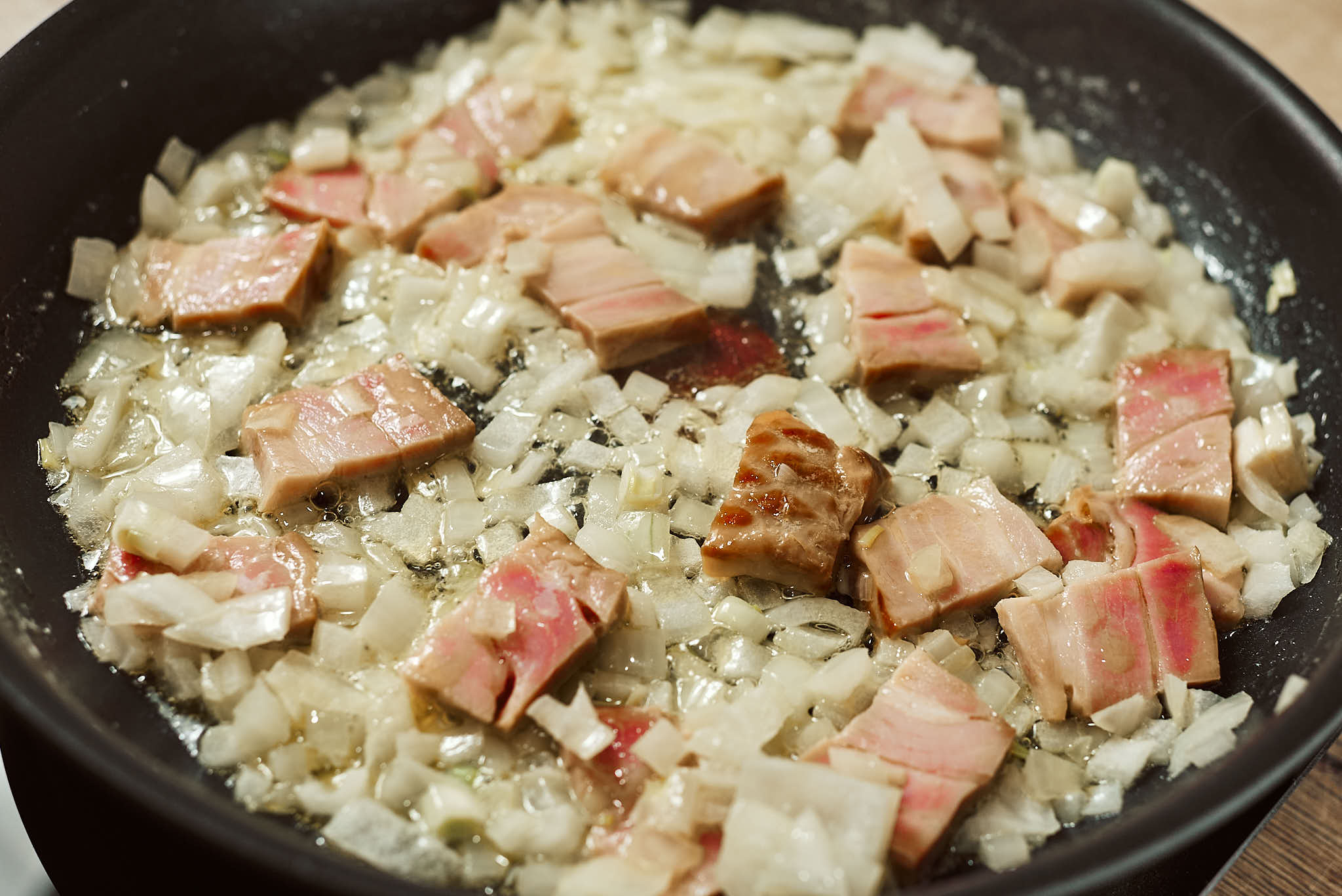 Onion and bacon sautéing in butter for mushroom sauce