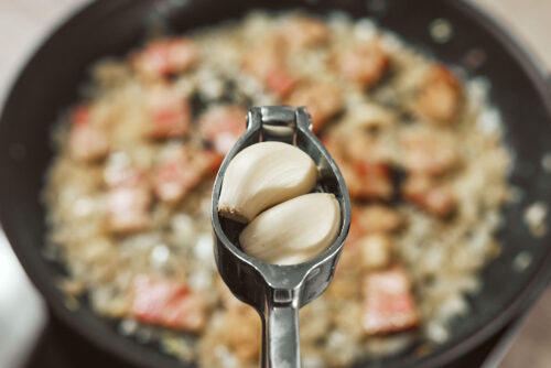 Garlic pressed into skillet with onion and bacon