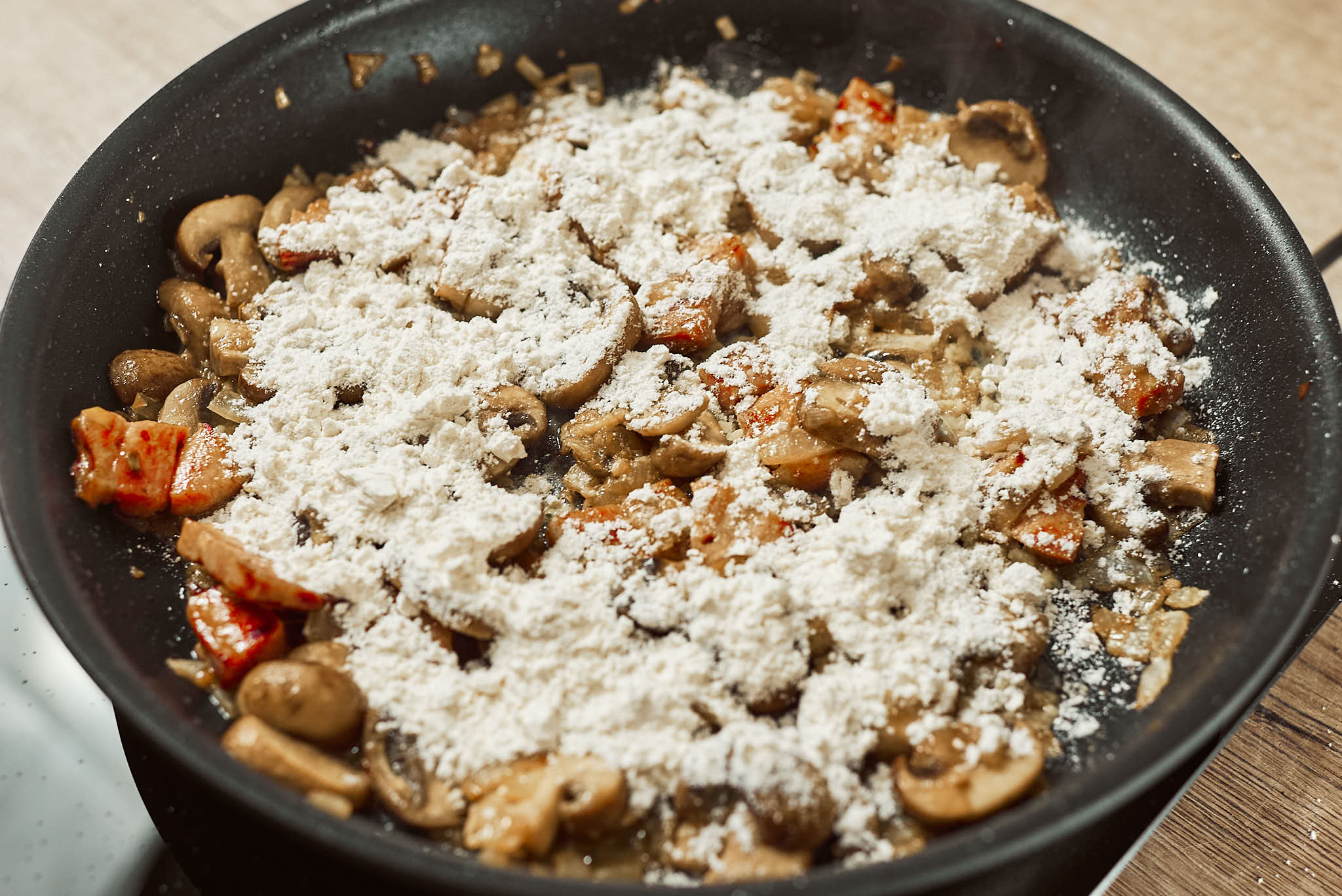 Mushrooms sprinkled with flour before adding broth