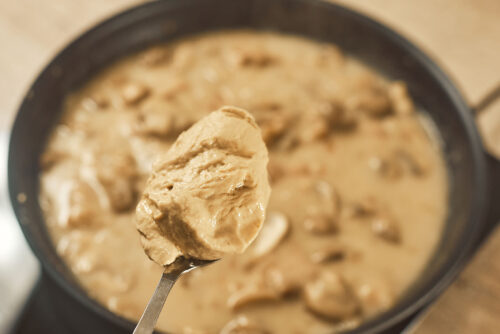 Mustard added to creamy mushroom sauce in the skillet
