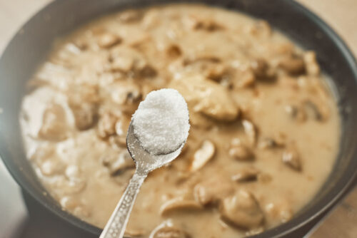 Salt added to mushroom cream sauce for seasoning