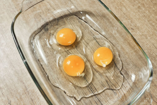 Eggs cracked into a bowl for breading pork schnitzel