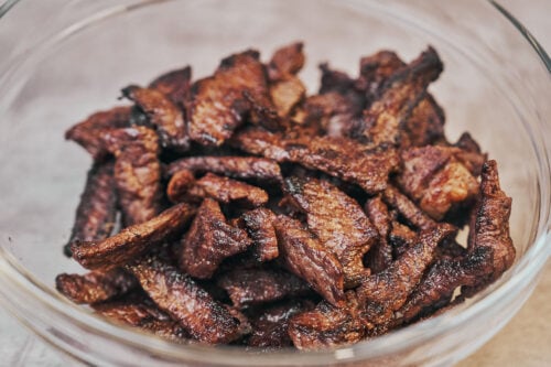 Cooked beef strips resting in a bowl for beef stroganoff