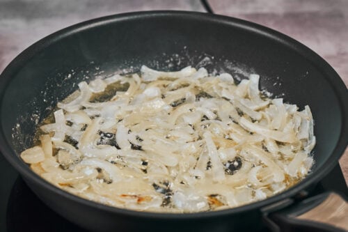 Sautéing sliced onions until soft for beef stroganoff