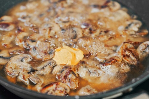 Simmering mushroom sauce until thickened for beef stroganoff