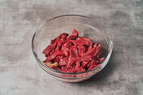 Beef strips in a bowl prepared for beef stroganoff